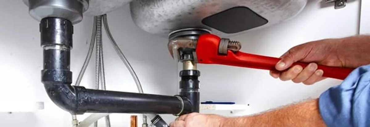 Garbage disposal repair technician tightening the sink drain and disposal connection in Minneapolis, MN