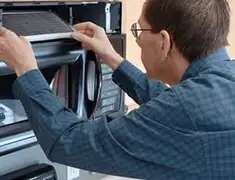 Appliance repair technician replacing a microwave vent filter in Minneapolis, MN