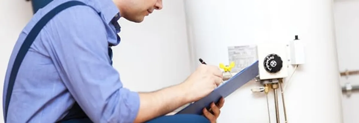 Water heater repair technician inspecting the unit and recording service notes in Minneapolis, MN